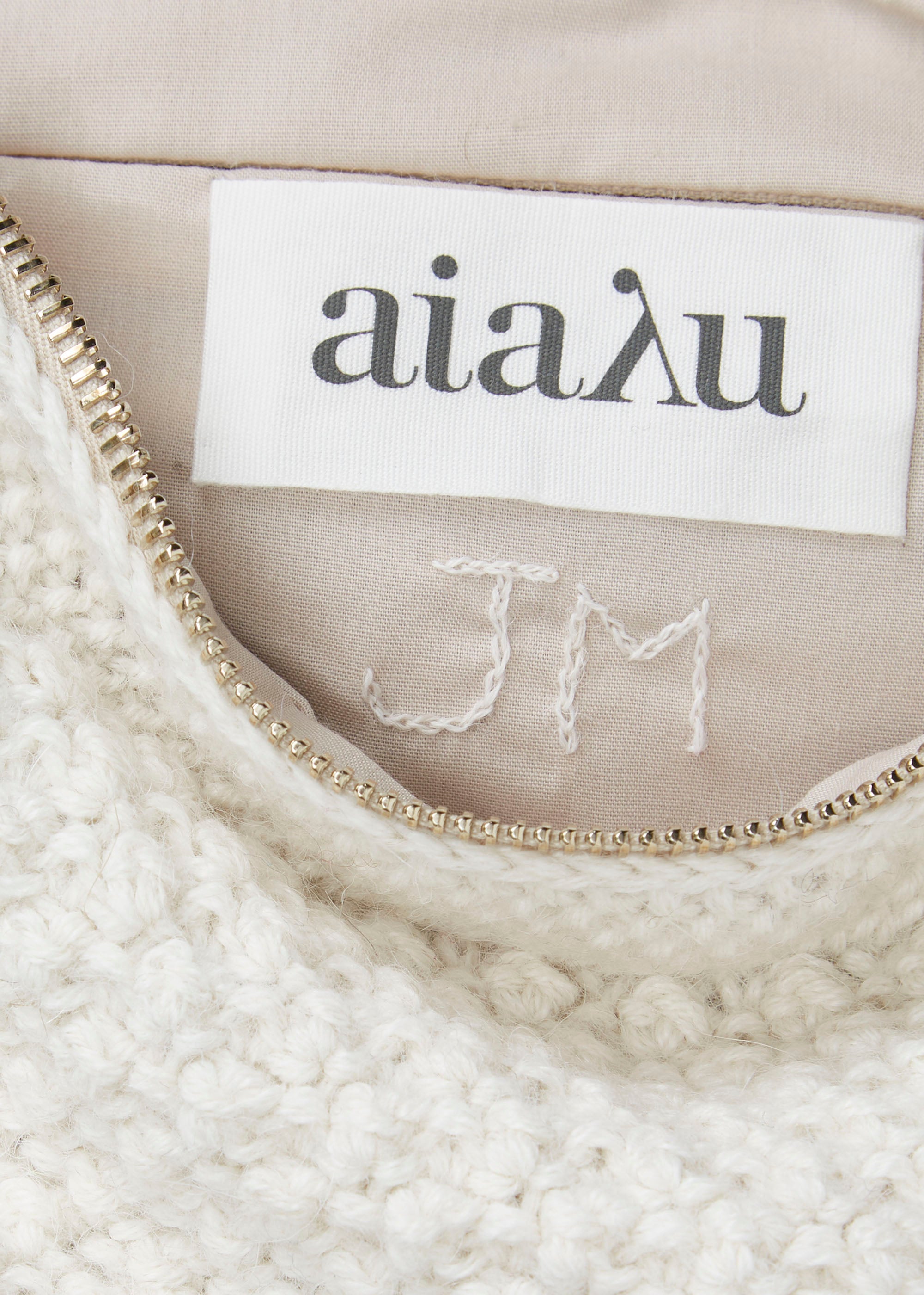 Embroidered initials of the woman who knitted the clutch.